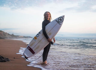 Ainhoa Leiceaga avec sa planche de surf sur le bord de plage